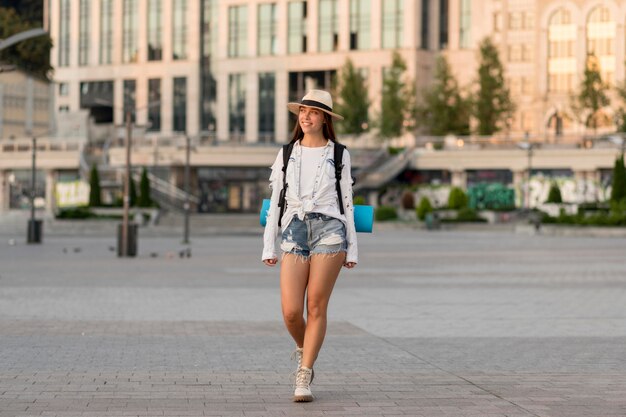 Vooraanzicht van vrouw met hoed die rugzak draagt terwijl alleen reist