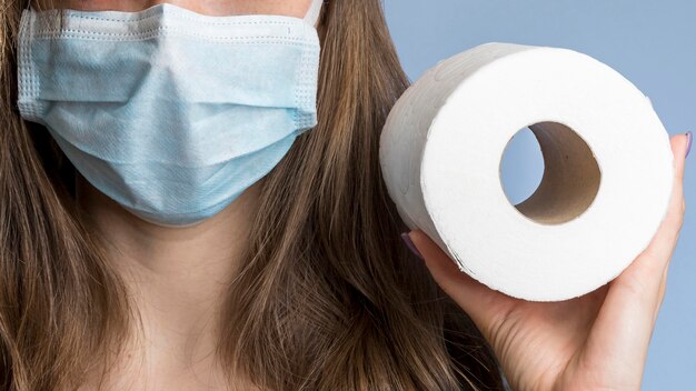 Vooraanzicht van vrouw met medisch toiletpapier van de maskerholding