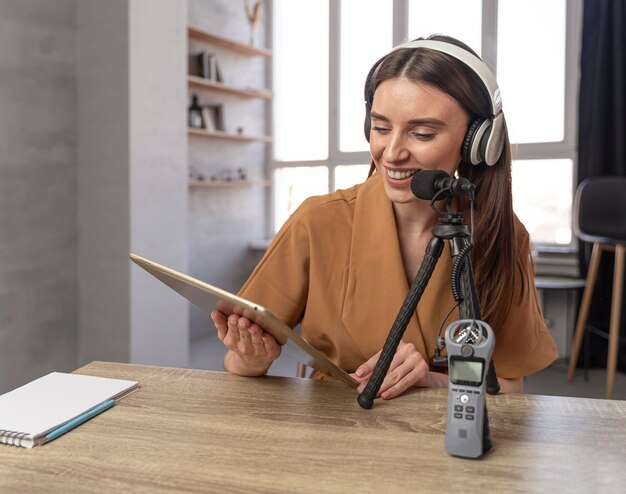 Vooraanzicht van vrouw podcasting met microfoon en tablet