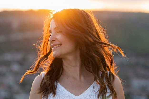 Gratis foto vooraanzicht van vrouw poseren buiten in de zonsondergang