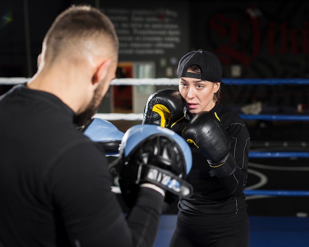 Vooraanzicht van vrouwelijke bokser training tijdens het dragen van beschermende handschoenen