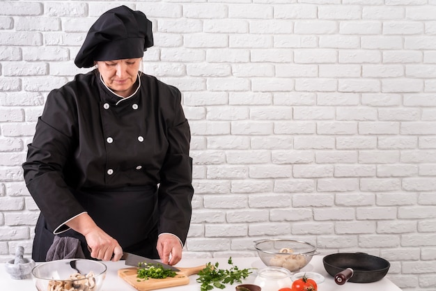 Vooraanzicht van vrouwelijke chef-kok hakken greens