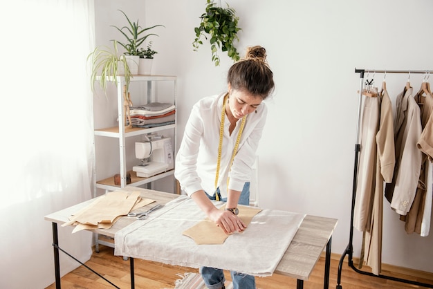 Vooraanzicht van vrouwelijke kleermaker die in de studio werkt