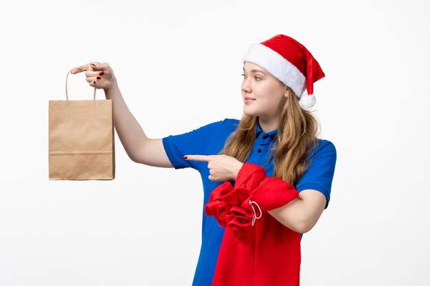 Vooraanzicht van vrouwelijke koerier met cadeau op witte muur