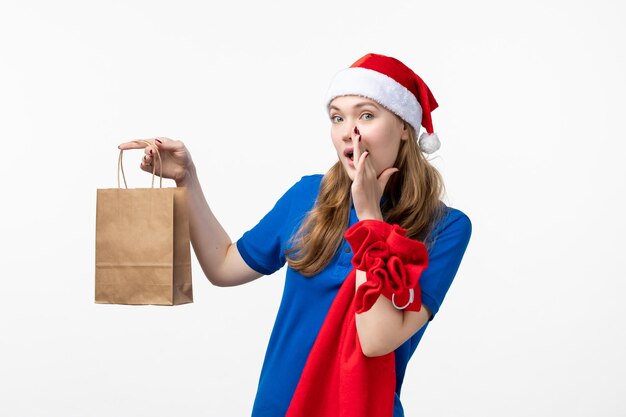 Vooraanzicht van vrouwelijke koerier met cadeau op witte muur