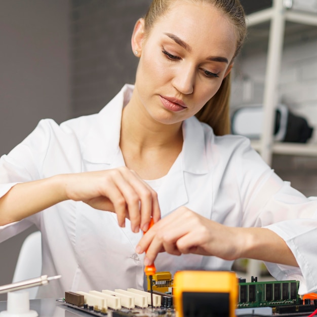 Gratis foto vooraanzicht van vrouwelijke technicus met elektronicabord