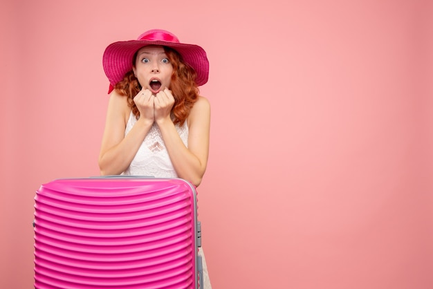 Vooraanzicht van vrouwelijke toerist met roze zak met geschokt gezicht op roze muur