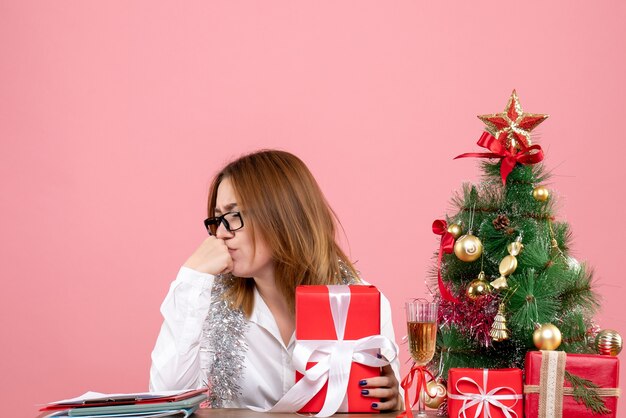 Vooraanzicht van vrouwelijke werknemer bedrijf aanwezig op roze