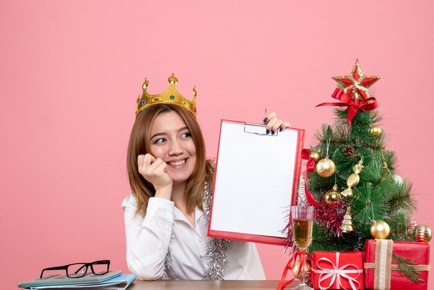 Vooraanzicht van vrouwelijke werknemer in het dossiernota van de kroonholding op roze