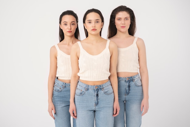 Vooraanzicht van vrouwen in tanktops en jeans poseren in minimalistische portretten