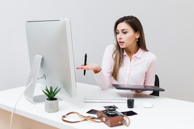 Vooraanzicht van werkende vrouw die computer bekijkt en niet begrijpt wat er aan de hand is