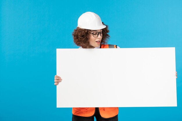 Vooraanzicht van werkneemster in uniform op de blauwe muur