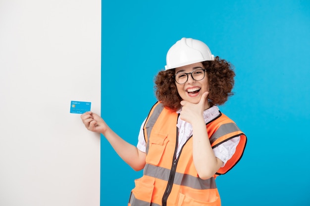 Vooraanzicht van werkneemster in uniform op de blauwe muur