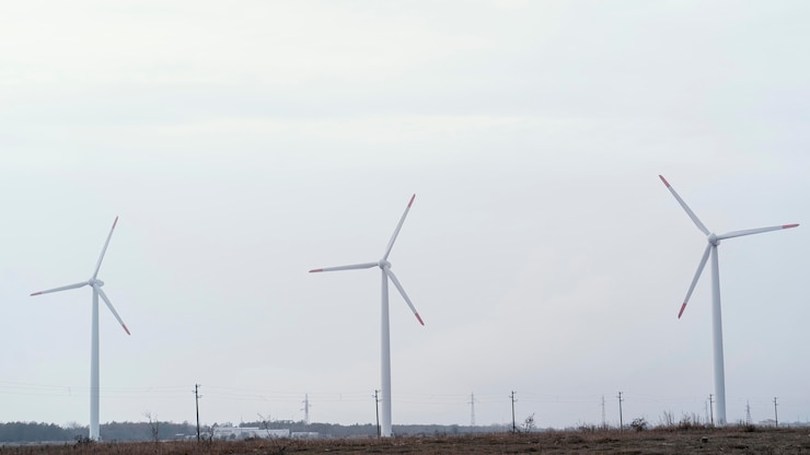 Gratis Foto vooraanzicht van windturbines in het veld die elektrische energie opwekken