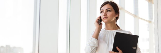 Vooraanzicht van zakenvrouw praten aan de telefoon met kopie ruimte