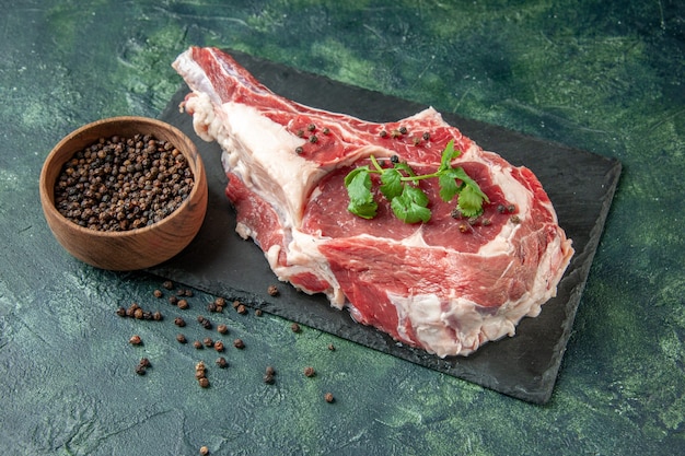 Vooraanzicht vers vleesplakje met peper op donkerblauw keuken dier koe kip voedsel kleur slager vlees