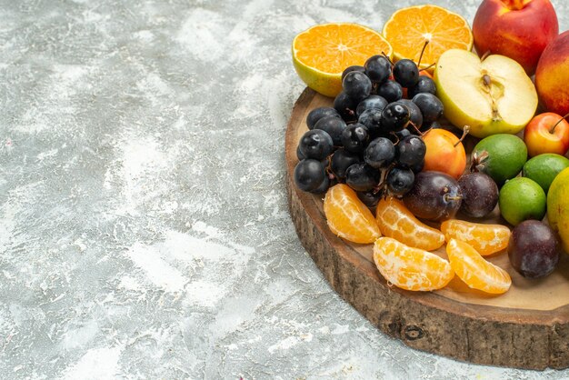 Vooraanzicht verschillende fruitsamenstelling gesneden geheel vers fruit op witruimte