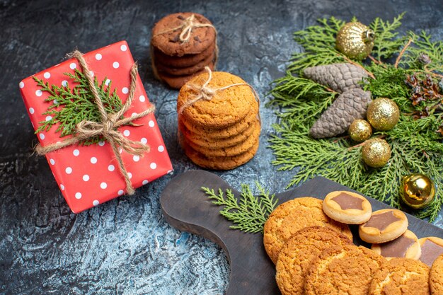 Vooraanzicht verschillende heerlijke koekjes met cadeau op licht-donker oppervlak