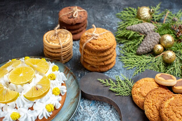 Vooraanzicht verschillende heerlijke koekjes met cake op het licht-donkere oppervlak