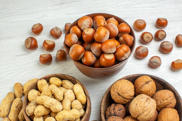Vooraanzicht verschillende noten pinda's hazelnoten en walnoten op witte ondergrond
