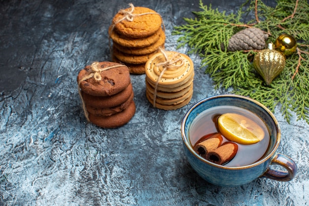 Vooraanzicht verschillende zoete koekjes met kopje thee op de lichte achtergrond