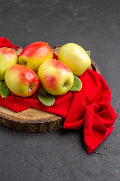 Gratis foto vooraanzicht verse appels rijp fruit op rood weefsel en grijze tafel verse fruitboom rijp