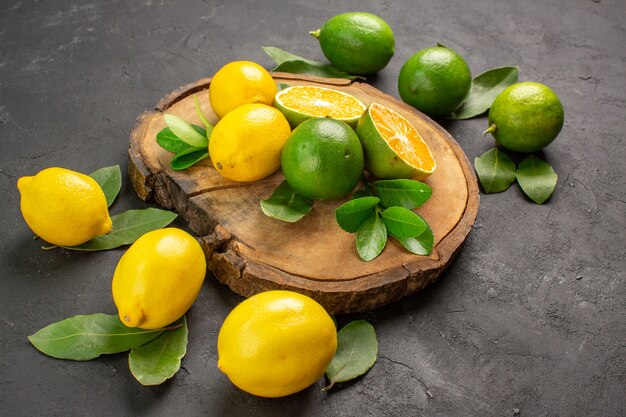 Vooraanzicht verse citroenen op donkere achtergrond fruit limoen zure citrus