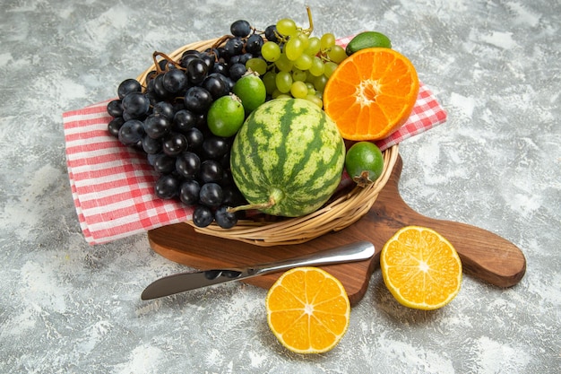 Vooraanzicht verse donkere druiven met sinaasappel en watermeloen op witte achtergrond rijpe vruchten zachte vitamine boom vers