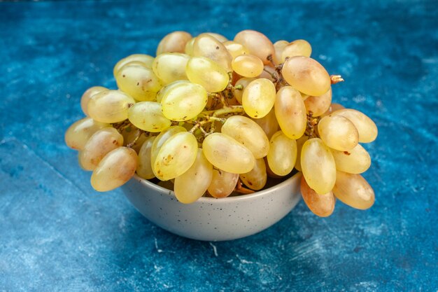 Vooraanzicht verse druiven in plaat op blauwe kleur fruit zacht rijp sap foto