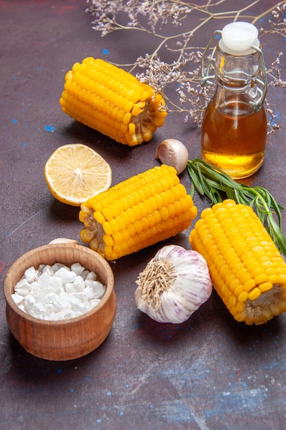 Gratis foto vooraanzicht verse gele likdoorns met knoflook op donkere oppervlakte maïs snack eten rauw vers