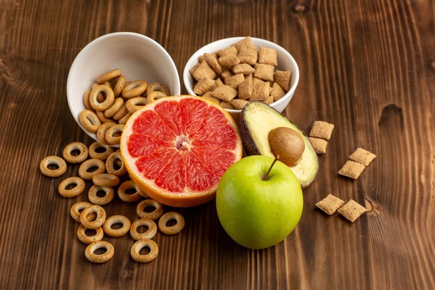 Vooraanzicht verse grapefruit met crackers en koekjes op houten bureau