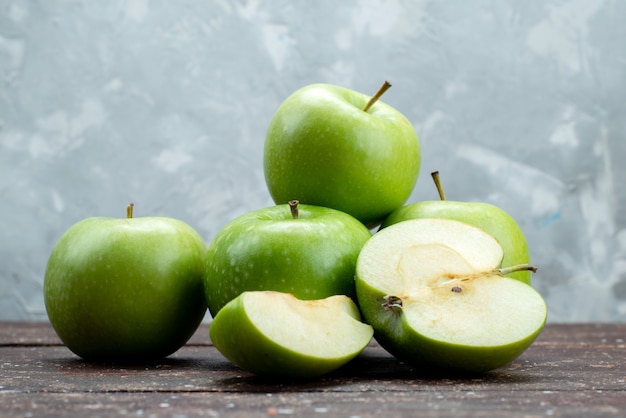 Vooraanzicht verse groene appels gesneden en geheel op grijs