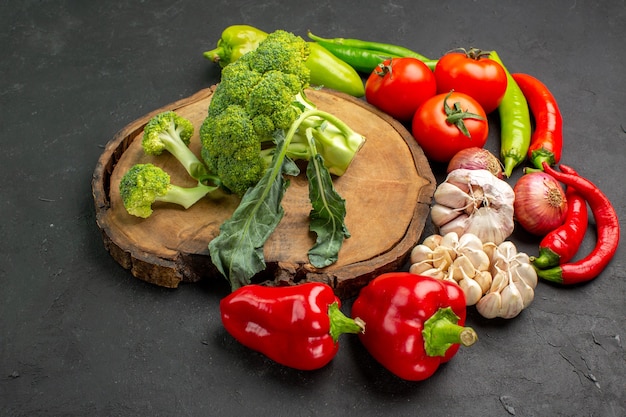 Vooraanzicht verse groene broccoli met verse groenten op donkere achtergrond