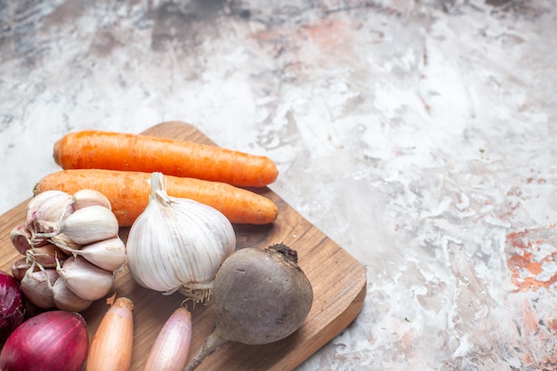 Gratis foto vooraanzicht verse groenten met knoflook op witte tafel