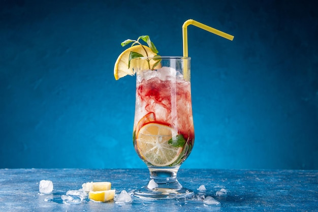 Vooraanzicht verse koele limonade met citroen en ijs op blauwe achtergrond sap drinken cocktail kleuren water fruit koud