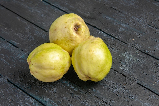 Vooraanzicht verse kweeperen zacht en zuur fruit op donkerblauw bureau rijpe foetus verse boom zure plant fruit