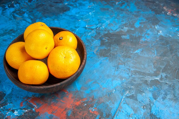Vooraanzicht verse mandarijnen binnen plaat op de blauwe tafel