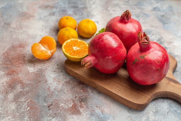 Vooraanzicht verse mandarijnen met rode granaatappels op lichte achtergrond foto sap kleur vitamine smaak fruit exotische boom