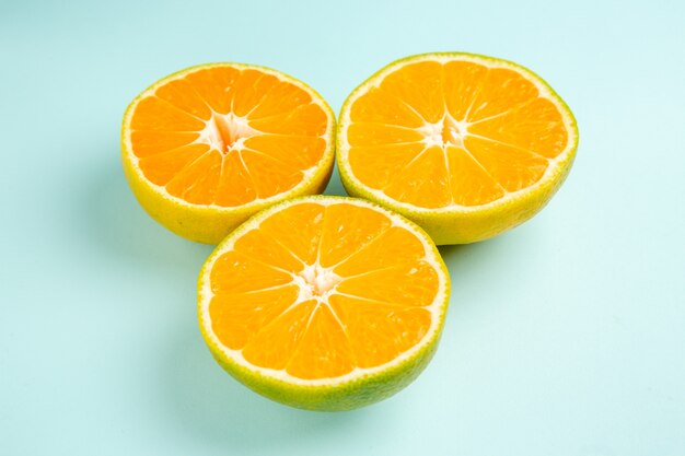 Vooraanzicht verse mandarijnschijfjes op de lichtblauwe tafel