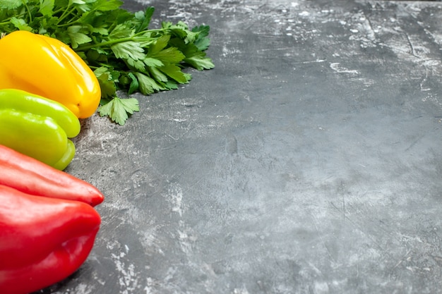 Vooraanzicht verse paprika met greens op donkere tafel