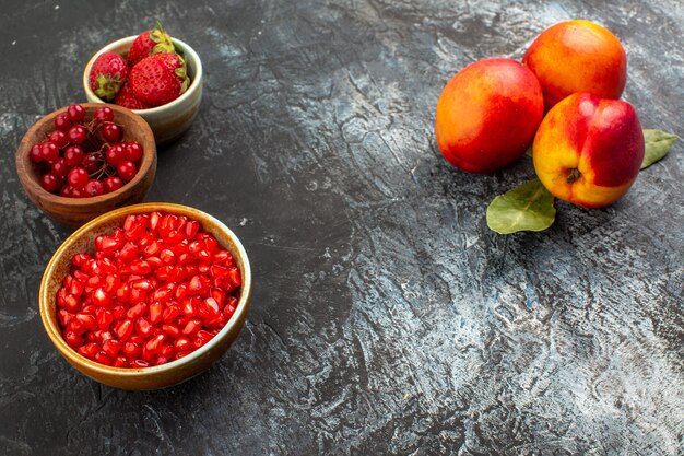 Vooraanzicht verse perziken met rood fruit op licht-donkere tafel fruitboomtuin
