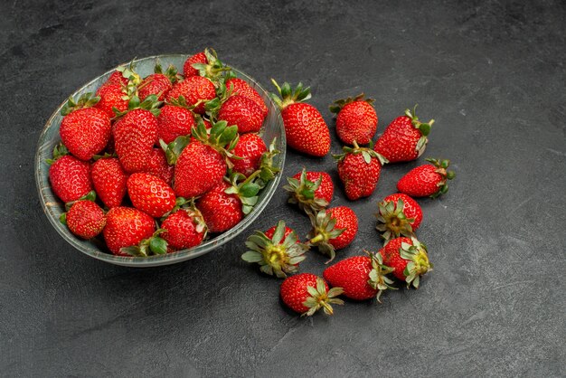 Vooraanzicht verse rode aardbeien in plaat en op grijze achtergrond bessensap kleur zomer