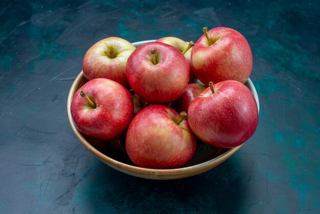 Vooraanzicht verse rode appels sappig en zacht binnen plaat op donkerblauw bureau fruit verse zachte vitamine