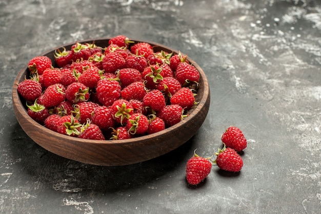 Vooraanzicht verse rode frambozen binnen plaat op een grijze foto kleur bes fruit kleur cranberry wild