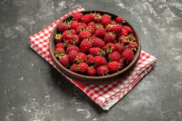 Gratis foto vooraanzicht verse rode frambozen binnen plaat op grijze fruitbes kleur cranberry wilde foto