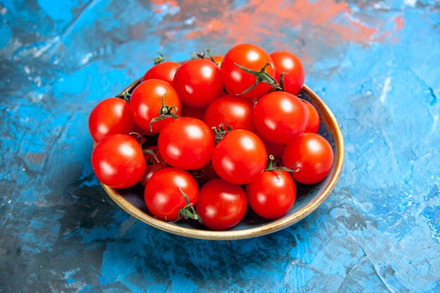 Vooraanzicht verse rode tomaten binnen plaat op de blauwe tafel