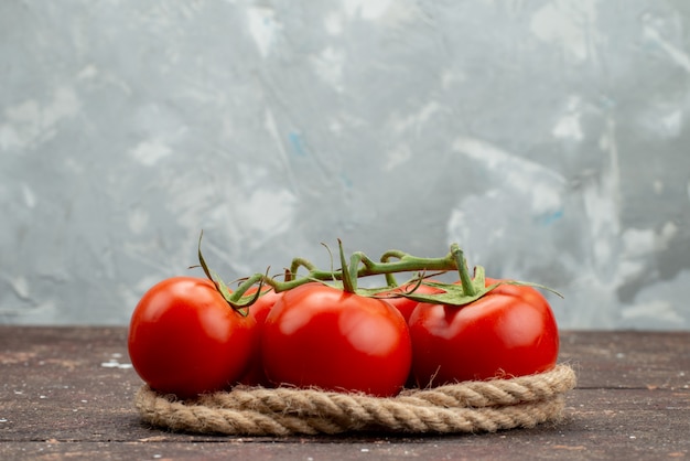 Gratis foto vooraanzicht verse rode tomaten rijp en geheel op wit, met touwen plantaardige fruit bessen voedsel kleur