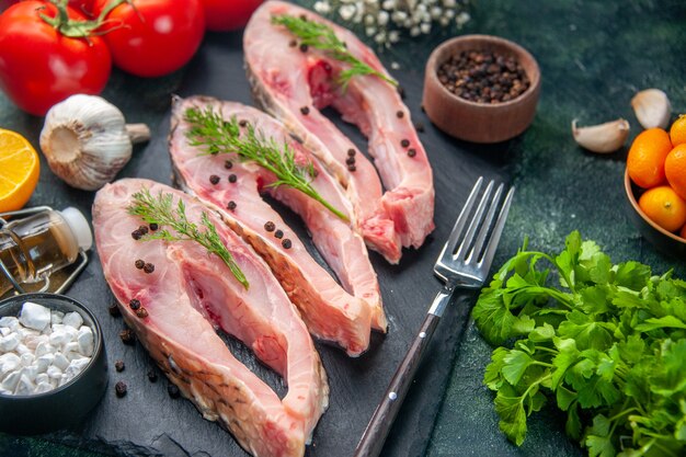 vooraanzicht verse vis plakjes met rode tomaten en greens op donkere ondergrond zeevruchten salade maaltijd oceaan rauw vlees water foto diner kleur