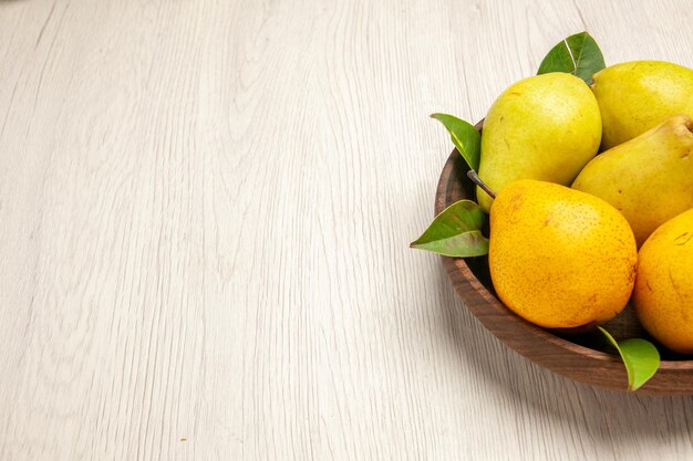 Vooraanzicht verse zachte peren zoete vruchten in plaat op witte bureauvruchten gele verse zoete rijpe
