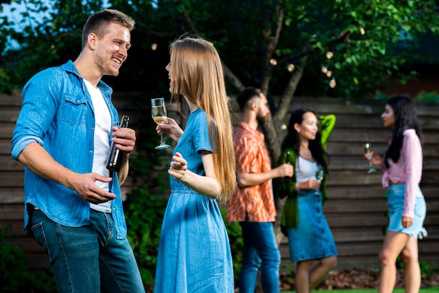 Vooraanzicht vrienden met drankjes dansen